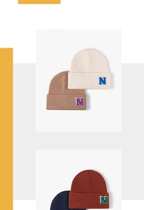 Detail of knitted beanie with letter N patch, showcasing wool texture and cuffed design