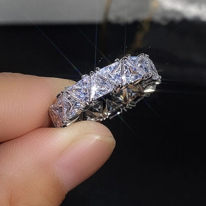 Macro shot of silver eternity band with triangle-cut zircons in a multi-prong setting
