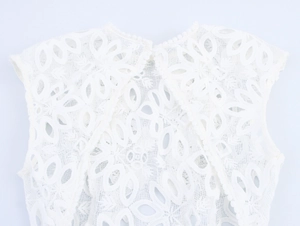 Détail macro du tissu en dentelle florale blanche avec bordure élégante à pompons