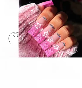 Detail of pink gradient press-on nails with 3D white floral petals and rhinestone accents