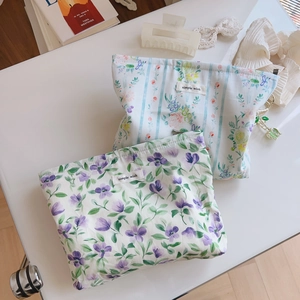 Close-up of floral cotton cosmetic bags with zippers and minimalist brand labels