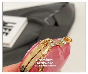Detail shot of the high-quality gold hardware and heart-shaped pink clutch bag finish