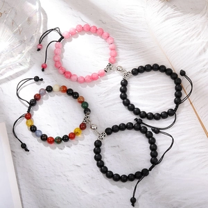 Matching magnetic couple bracelets with chakra natural stones on marble background