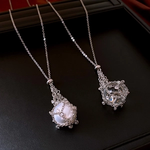 Close-up of pearl and crystal pendants inside silver mesh cages with zircon accents