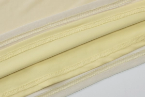 Detailed close-up showing reinforced stitching and mesh fabric of the yellow dress