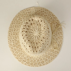 Detailed view of the hollow crochet weave pattern on this beige straw sun hat for women