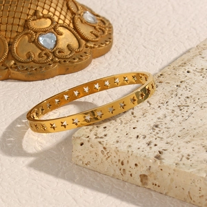 Detailed close-up of hollow star pattern on a rose gold stainless steel cuff bracelet