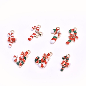 Macro detail of various Christmas candy cane enamel charms with gold edges and small rhinestones