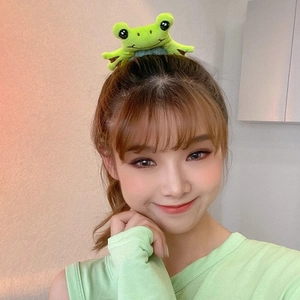 Cute green plush frog hair scrunchie shown on model for stylish hair styling