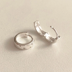 Detailed close-up of S925 sterling silver earrings featuring engraved star patterns