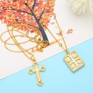 Detail of vintage gold cross necklace and religious medallion with zircon stones