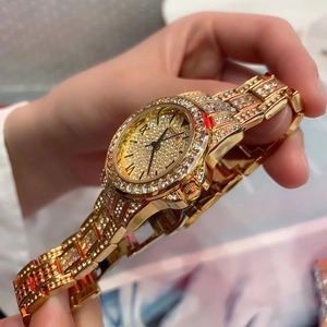 Luxury gold women's quartz watch featuring a full diamond setting and roman numeral dial