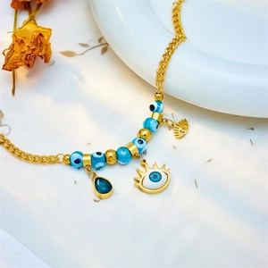 Golden titanium steel bracelet featuring evil eye charms and a blue teardrop gemstone