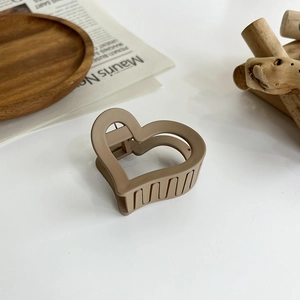 Elegant heart-shaped matte resin hair claw in khaki brown on a minimal white background