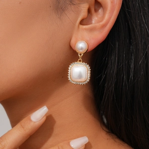 Elegant gold drop earrings set with vintage faux pearls and sparkling cubic zirconia stones