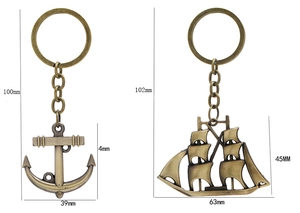Detail view of antique bronze sailboat and anchor keychains with precise size measurements