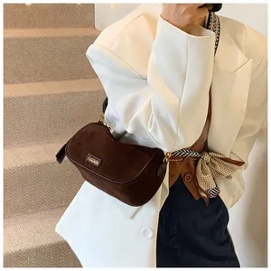 Detailed view of a dark brown suede pillow bag with golden fashion metal hardware