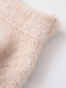 Close-up of soft pink lace-up knit fabric showing plush mohair texture and stitching