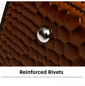 Close-up of silver metal rivet reinforcement on dark brown embossed crocodile leather handbag