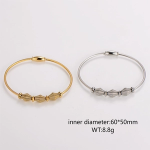Gold and silver spiral wire magnetic bracelets with textured beads on white background