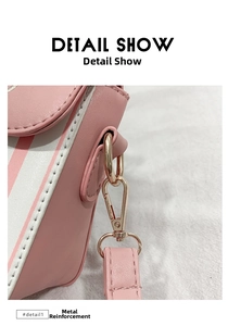 Detail of light gold metal buckle and strap stitching on pink striped PU crossbody bag