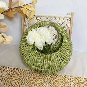 Handwoven green corn rope wall hanging basket with white flowers for home decor