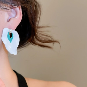 Detailed view of silver calla lily stud earrings with white petals and a small pearl accent