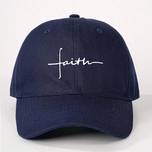 Close-up of embroidered white faith script on a navy blue washed cotton baseball cap