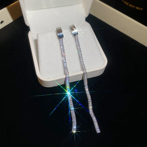 Close-up of sparkling zircon tassel earrings with silver finish on black velvet