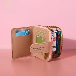 Detail of pink compact wallet showing card slots, ID window and gold zipper coin pocket