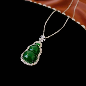 Detailed close-up of a green resin gourd pendant with sparkling zircon inlays on a dark background