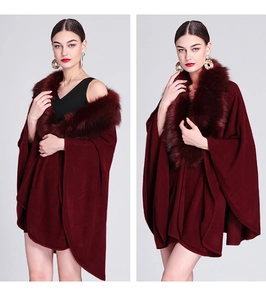 Detail view of the plush faux fox fur collar on a dark red knit cape cardigan