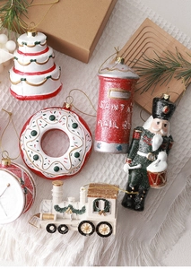 Flat lay of resin Christmas ornaments including Nutcracker, mailbox, and toy train