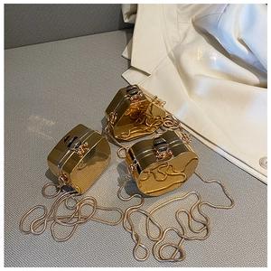 Detailed view of gold mirror finish hard shell clutch bags with bee shaped metal buckles
