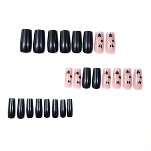 Press-on nails with black hearts and gold glitter lines on elegant nude and black bases