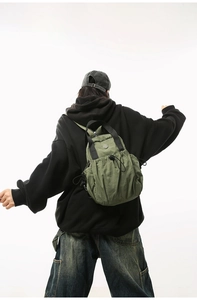 Detailed back view of the green lightweight nylon backpack worn by a model