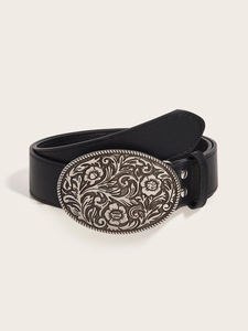 Detail of a vintage black leather belt with a large silver floral embossed buckle