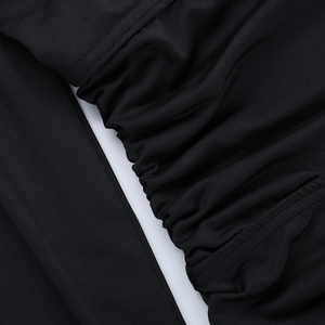 Detailed view of the black ruched fabric texture and pleated design of the mini dress