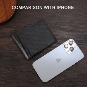 Confronto tra portafoglio in fibra di carbonio e iPhone su sfondo di legno scuro