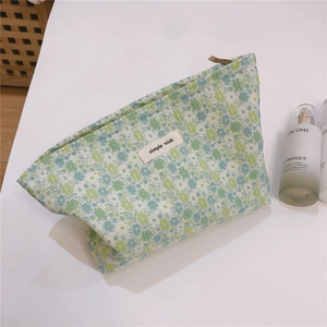 Close-up of green floral jacquard fabric and simple wish label on the makeup bag