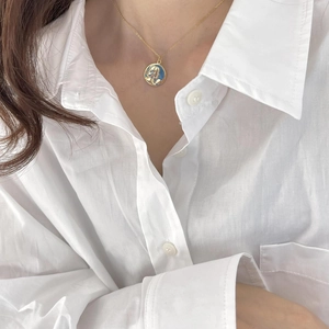 925 sterling silver gold portrait coin necklace with blue enamel on a model in white shirt
