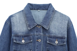 Detail view of denim jacket collar and chest pockets with high-quality metal buttons