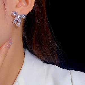 Elegant bow-knot earrings featuring sparkling cubic zirconia on a female model
