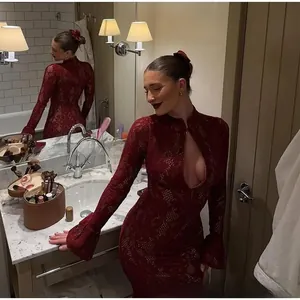 Détail de la robe en dentelle bordeaux montrant le décolleté ajouré et les motifs