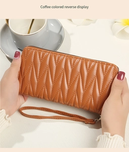 Detail of coffee brown wrinkled leather wallet with zipper closure and wrist strap