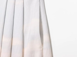 Macro shot of light blue pleated fabric detail showing fine crepe texture and side pocket