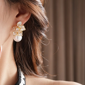 Detail view of a French vintage floral pearl drop earring worn on the earlobe