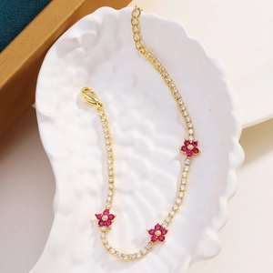Elegant gold flower bracelet with sparkling white zircons and ruby red blossoms