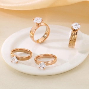 Close-up of rose gold plated rings with zircon stones on a white ceramic plate