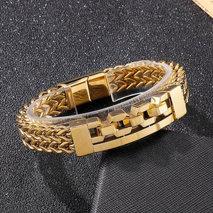 Macro detail of men's gold wheat chain bracelet with hollow geometric buckle on black surface
